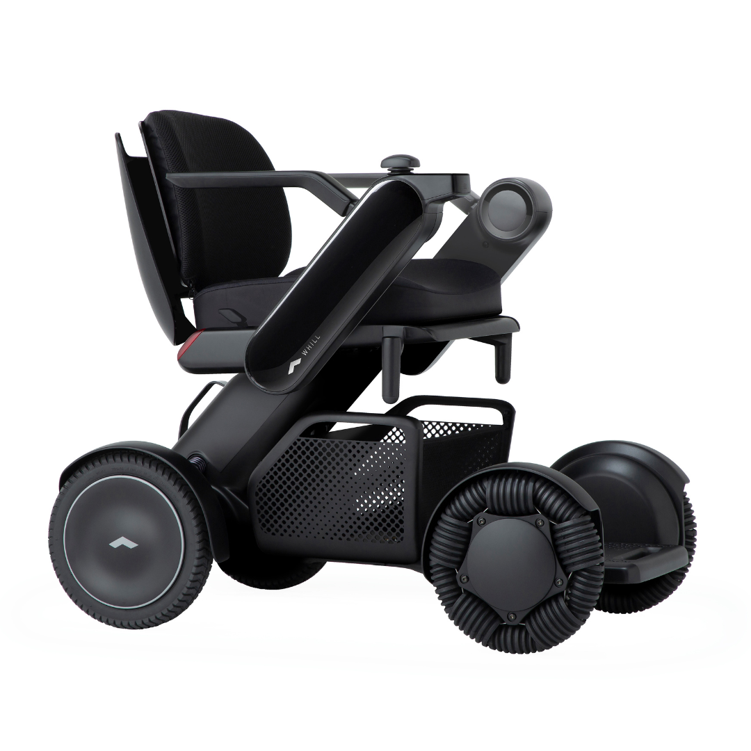 The Whill Model C2 Smart Power Chair - Compact Portable Mobility is a modern electric wheelchair with large wheels, black frame, armrests, and a mesh basket under the seat, designed for enhanced accessibility and mobility as a Class II medical device.